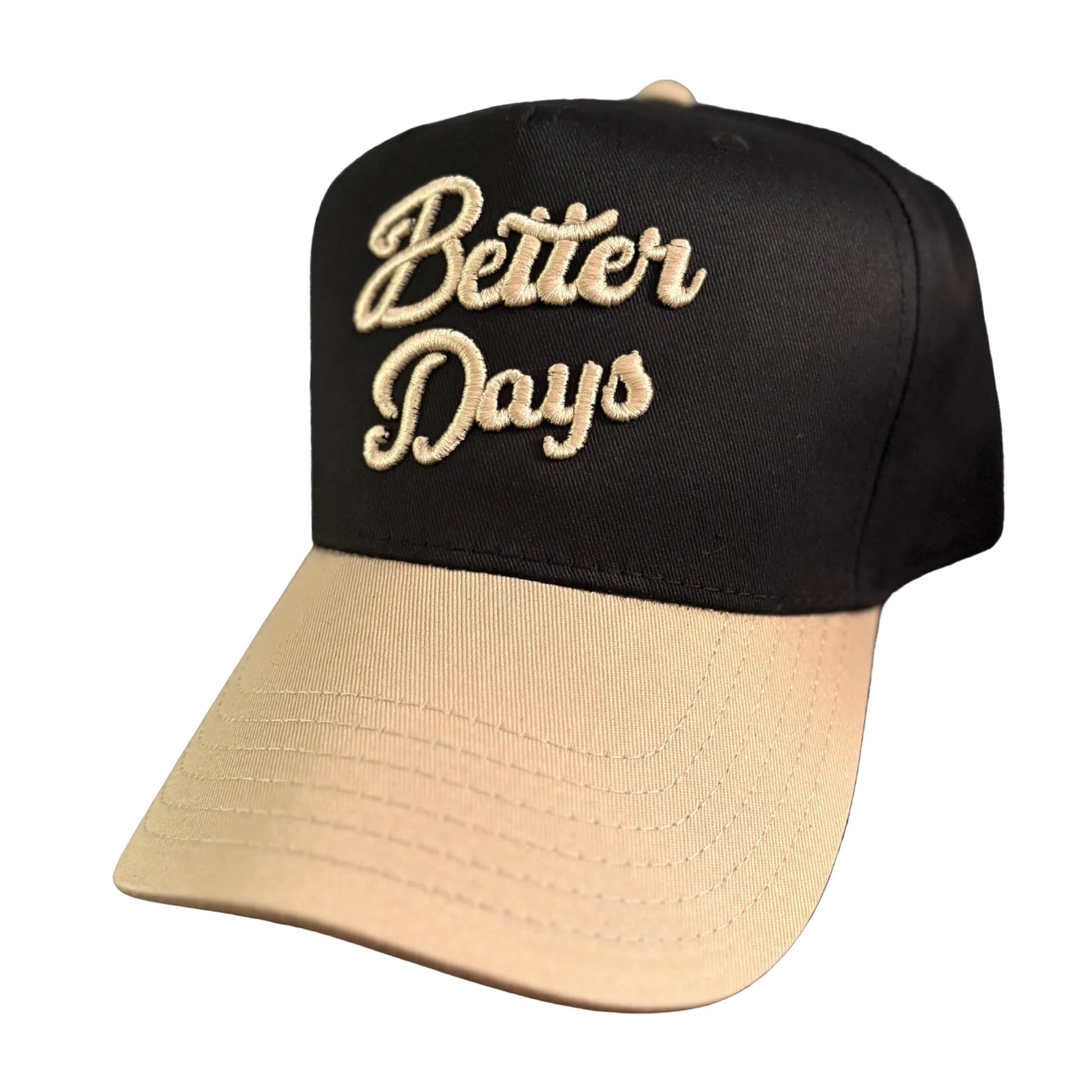 Better Days Company Long Island Gold Standard Hat with adjustable strap and embroidered logo sitting on a wooden surface.